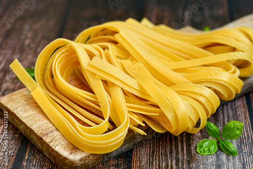 Raw fresh uncooked tagliatelle egg pasta , . Ready for cooking. Italian food concept. Kitchen poster