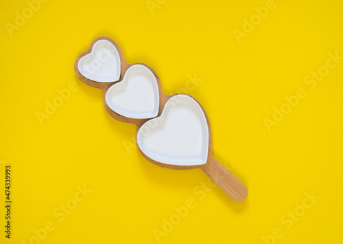 three white hearts on a yellow  background