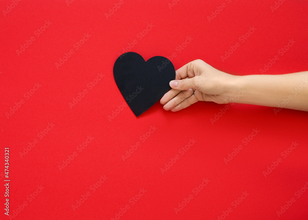 hand holding heart on a red background. Concept of love, Charity and Relief Work. Valentines day. Copy space hand holding heart on a red background. Concept of love, Charity and Relief Work. Valentines day. Copy space