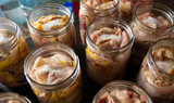 Raw chicken and duck pieces for stew in glass jars. The jars are prepared for autoclaving.