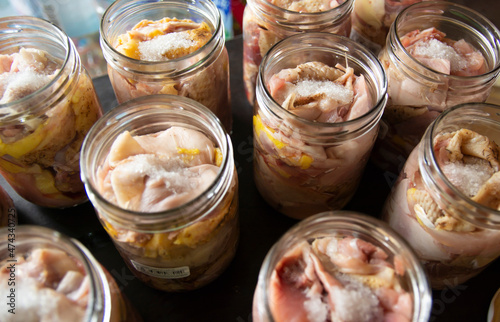 Raw chicken and duck pieces for stew in glass jars. The jars are prepared for autoclaving.
