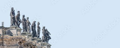 Fotografie, Tablou Old roof statutes of high ranked priests and saints lined up in Catholic Cathedral of Holy Trinity, Hofkirche in downtown of Dresden, Germany, details, at blue sky solid background with copy space