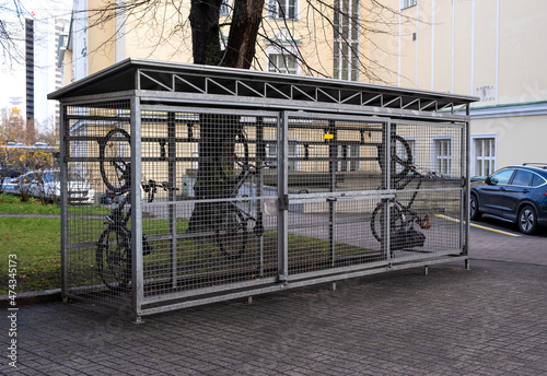 Bicycles in a cage on the street. Special garage-cage for bicycles. Bicycle storage device