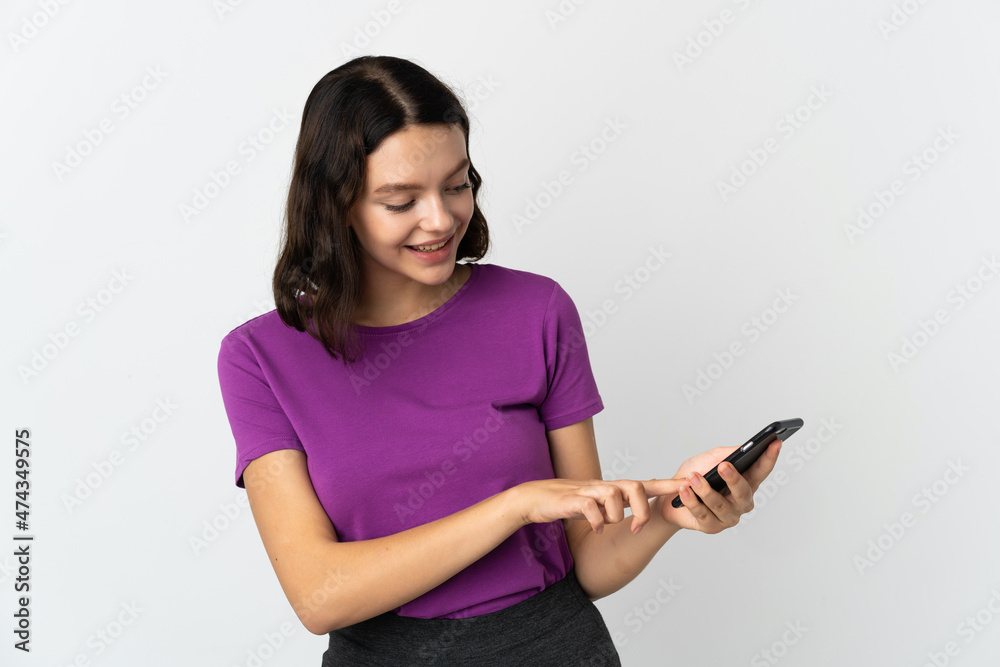 Teenager Ukrainian girl isolated on white background sending a message or email with the mobile Teenager Ukrainian girl isolated on white background sending a message or email with the mobile