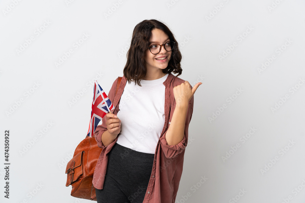 Teenager Ukrainian girl holding an United Kingdom flag pointing to the side to present a product Teenager Ukrainian girl holding an United Kingdom flag pointing to the side to present a product