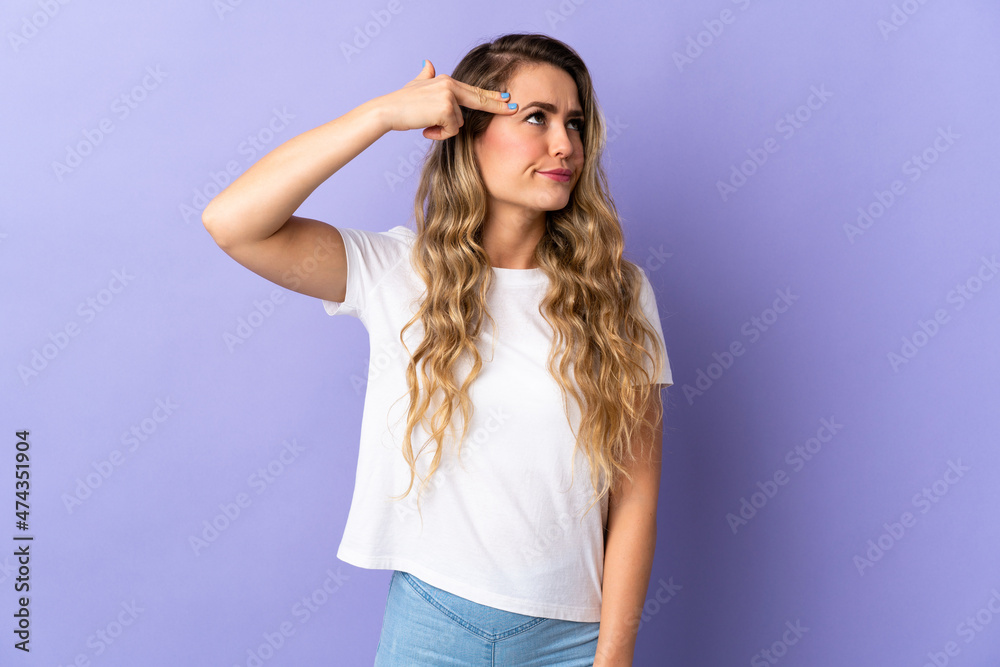 Young Brazilian woman isolated on purple background with problems making suicide gesture Young Brazilian woman isolated on purple background with problems making suicide gesture
