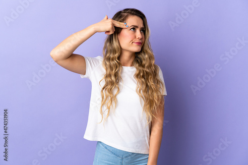 Young Brazilian woman isolated on purple background with problems making suicide gesture