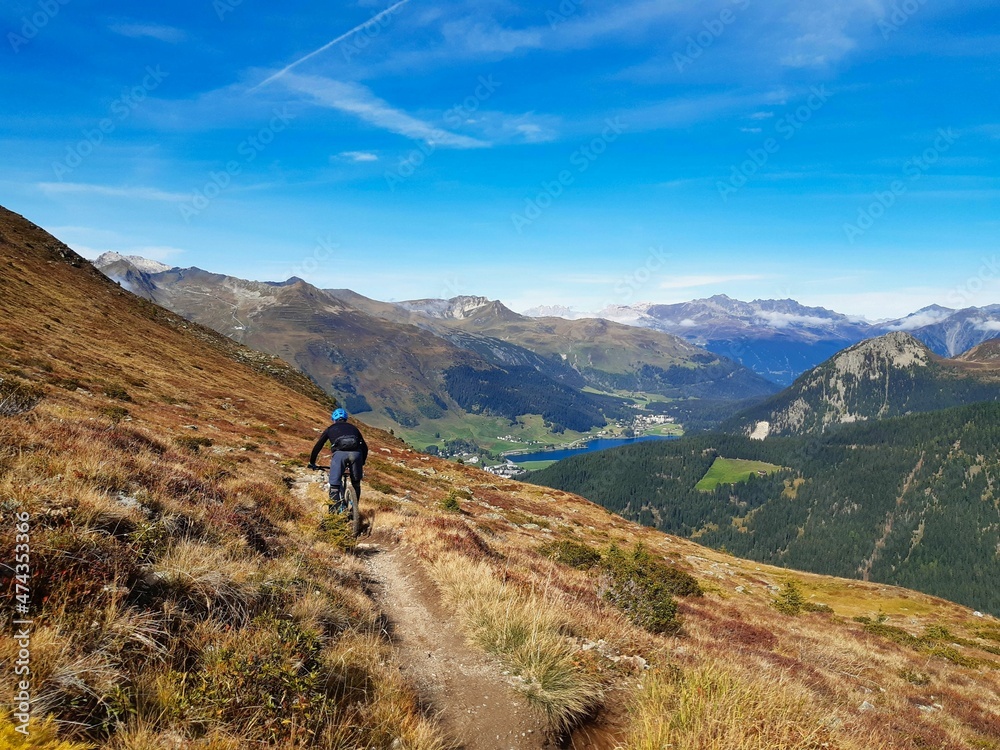 Trail for hiking or mountain biking enduro ride at Davos with view of lake of Davos, at autumn time, grison, Switzerland