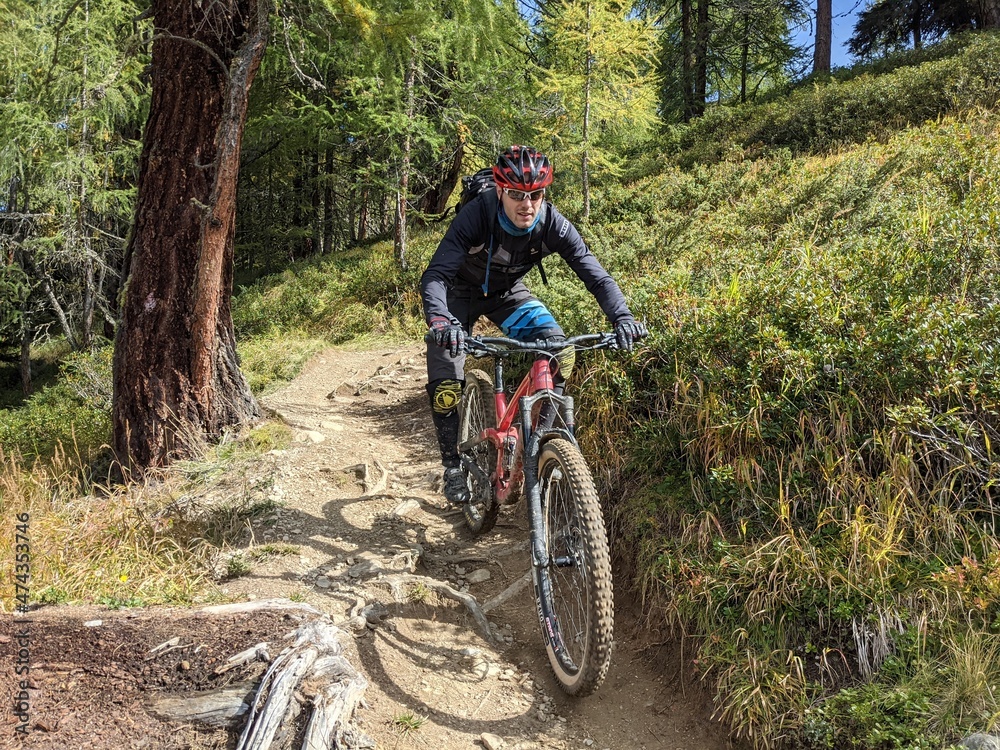 Naklejka premium Person rides enduro bike with much action and fun. Davos, Grison, Swiss Alps, Switzerland. Ride Mountainbike