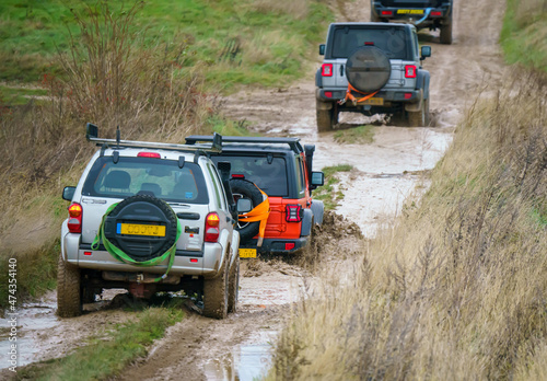4x4 off-road vehicles driving across mud and water-logged terrain, Salisbury Plain Wilts UK. Jeep Rubicon and Cherokee © Martin