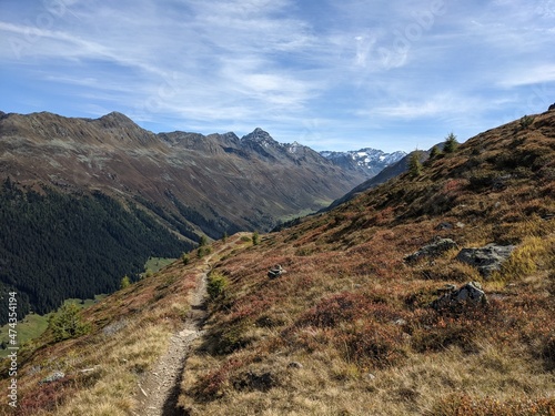 Trail for hiking or mountain biking enduro ride at Davos with view of lake of Davos, at autumn time, grison, Switzerland