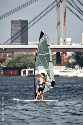 Windsurfer surfing on a windy day at the city river.