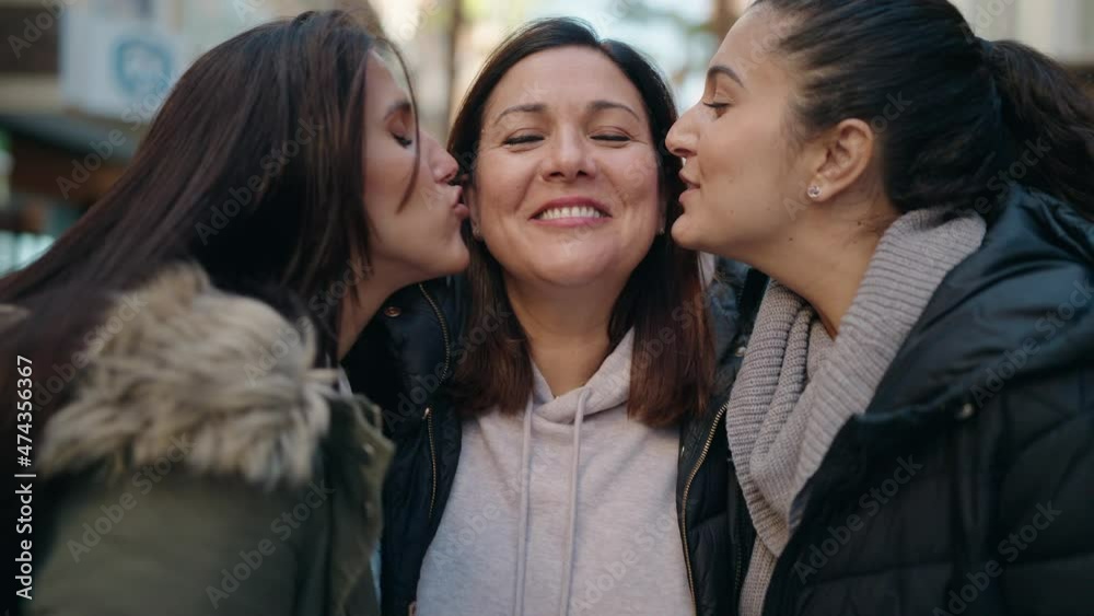 Mother and daughters kissing and hugging each other at street Mother and daughters kissing and hugging each other at street
