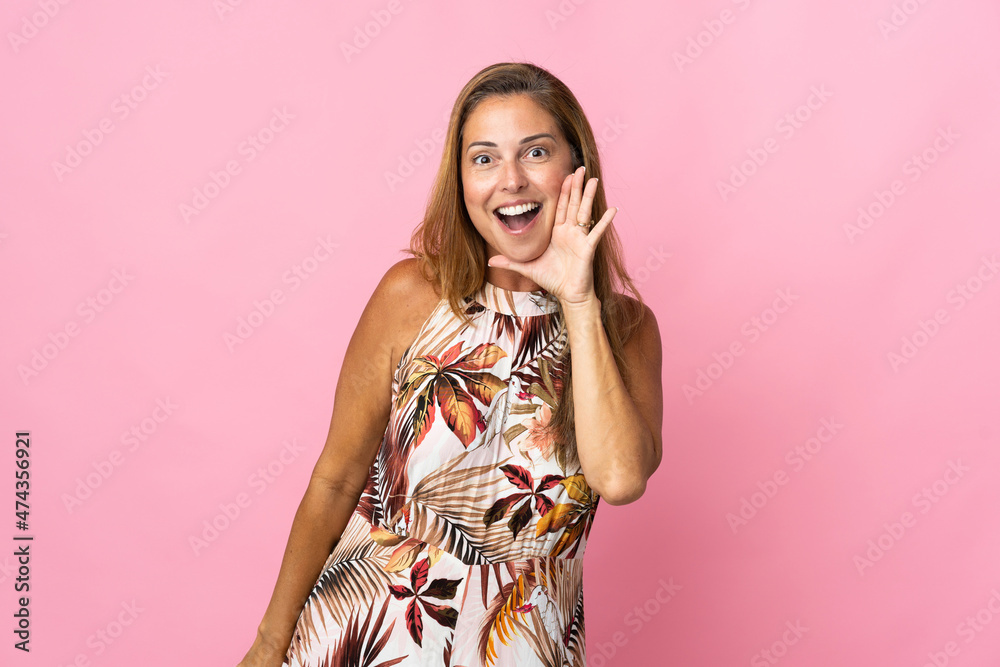 Middle age brazilian woman over isolated background shouting with mouth wide open Middle age brazilian woman over isolated background shouting with mouth wide open