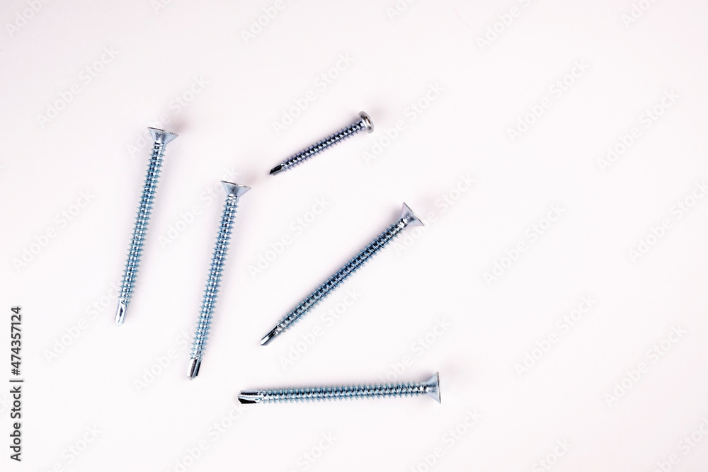 Self-tapping screws on a white background close-up. Self-tapping screw flugel on a white background Self-tapping screws on a white background close-up. Self-tapping screw flugel on a white background