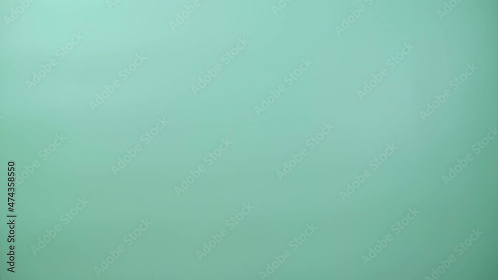 Yeti Bigfoot is peeking out of the scene. Loop video. Handmade crocheted toy. Surf green background. 4K