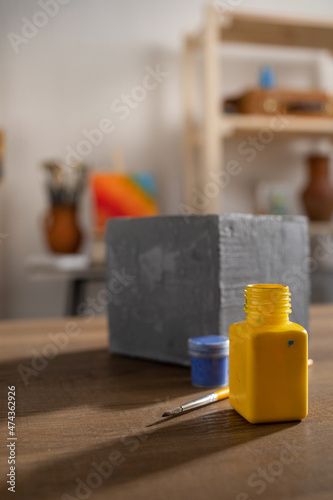 Painter tools in artist studio workplace. Paint brush and bottle on wooden table
