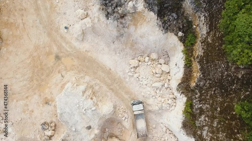 aerial footage excavator and truck work in limestone quarry. Heavy equipment in career.