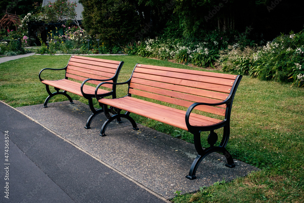 Two wooden benches with iron cast frames in park Two wooden benches with iron cast frames in park