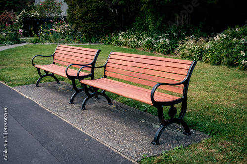 Two wooden benches with iron cast frames in park