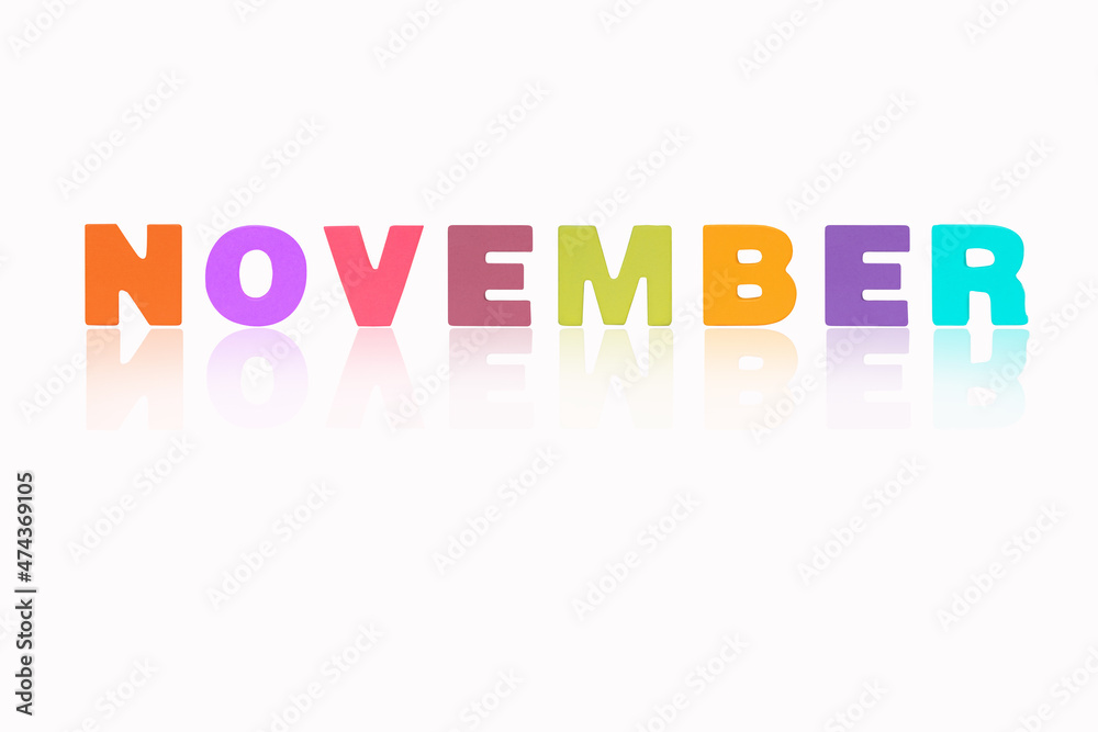 NOVEMBER month English made of wood  isolated on white background. Colorful wooden english alphabets set sort. letter made of wood arrange alphabet as categorize word. Poster banner design.