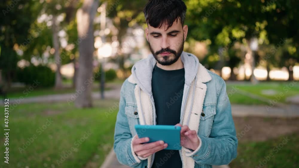 Young hispanic man smiling confident using touchpad at park Young hispanic man smiling confident using touchpad at park