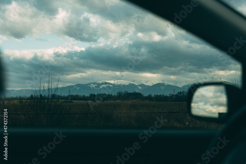 Photo view of mountains from car during cloudy day.
