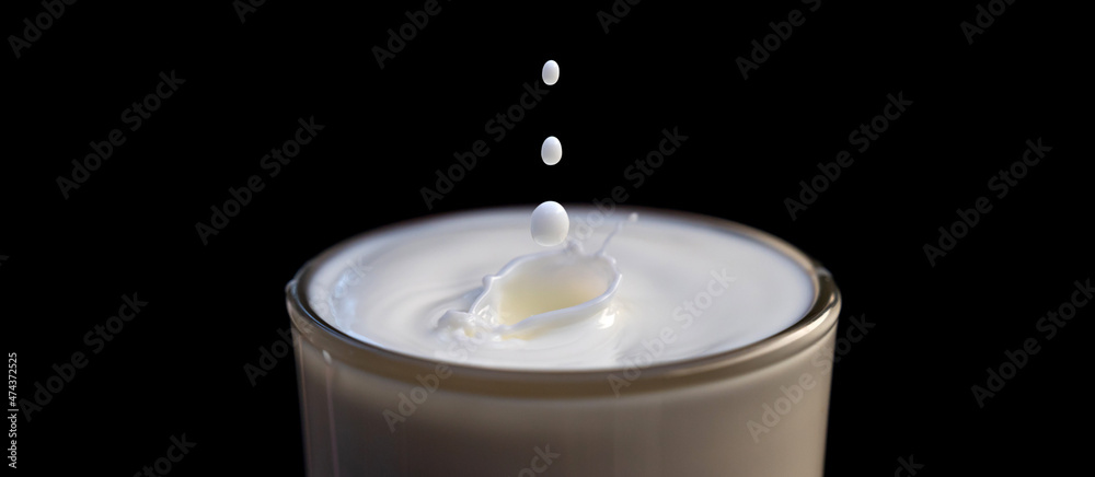 Splashing in a glass of milk on black background.Photo select focus. Splashing in a glass of milk on black background.Photo select focus.