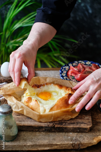 Adjaruli (Acharuli) Khachapuri, Georgian cheese bread. Traditional Georgian recipe made with a bread dough, filled with cheese and crowned with an egg and a butter. 