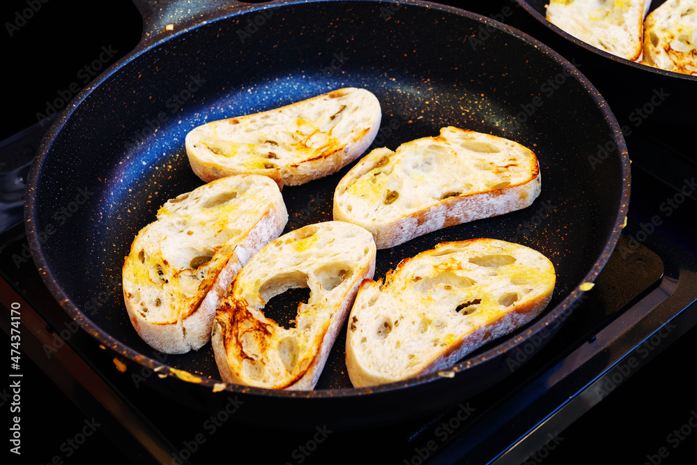 Toasting bread in a large skillet. Cooking food at home and outdoors. Close-up