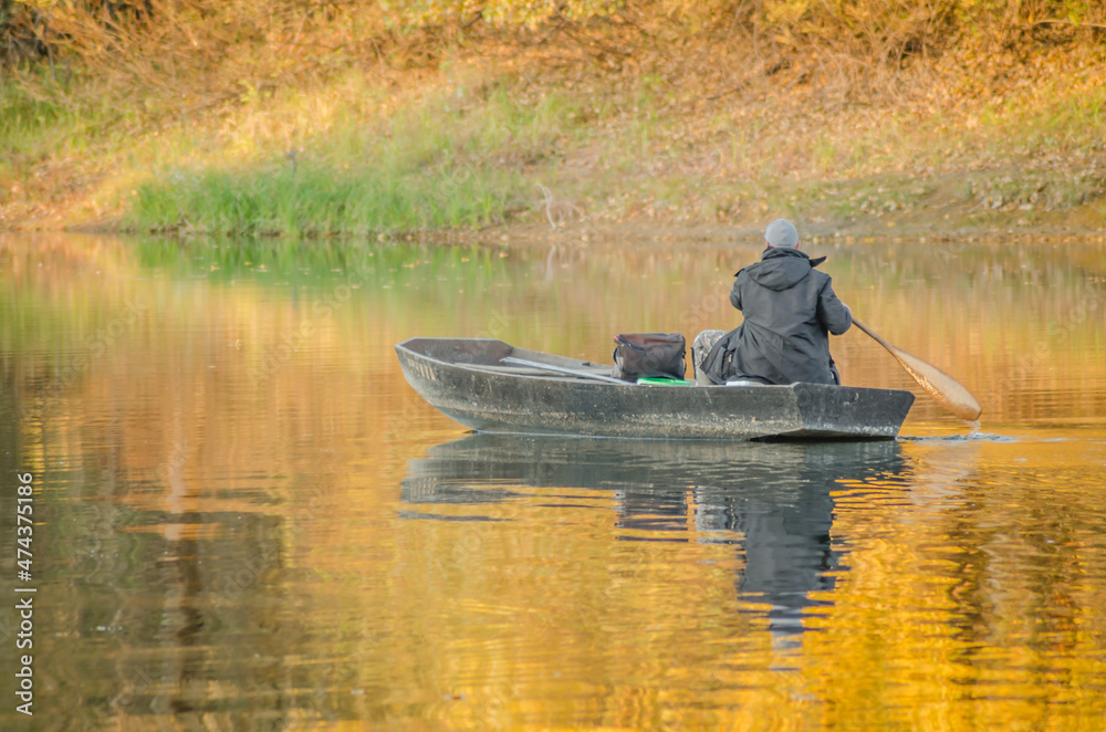 Begec, Serbia - October 30. 2021: Sport fisherman in a boat on an artificial lake near Novi Sad. Begec, Serbia - October 30. 2021: Sport fisherman in a boat on an artificial lake near Novi Sad.