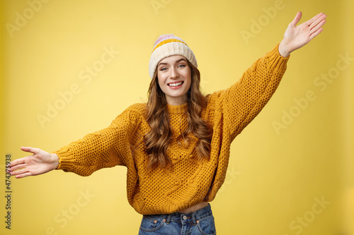 Friendly happy charming smiling cute girl inviting friends joyfully spread hands embracing wanna hug cuddle dear guest grinning cheerful, having fun expressing postivity good mood photo