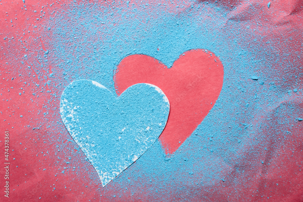 Valentine's Day. Two hearts are a symbol of love, one sprinkled with bright blue powder and the other on a red textured background.