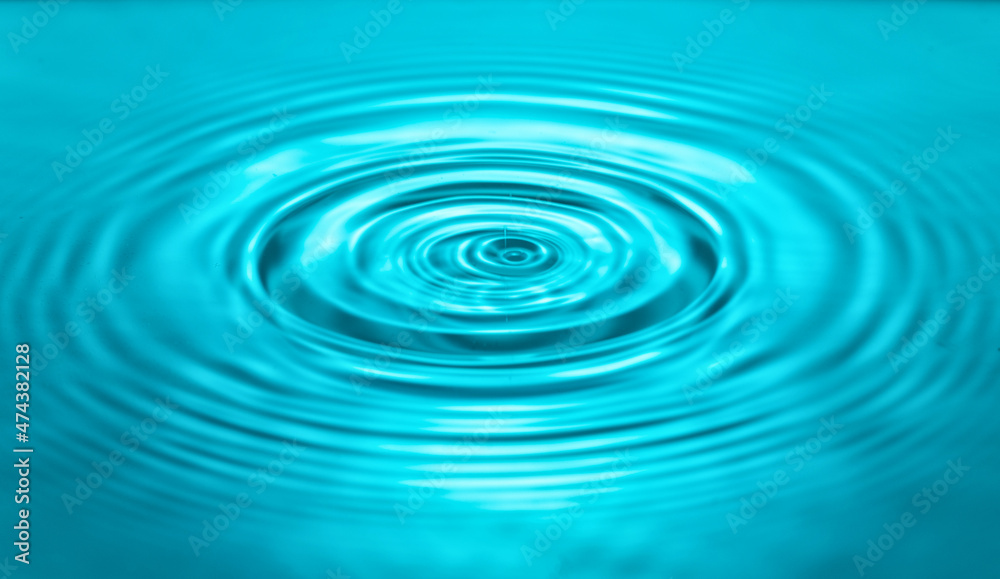 falling drops on the water surface, splash, ripples on the water, blue color falling drops on the water surface, splash, ripples on the water, blue color