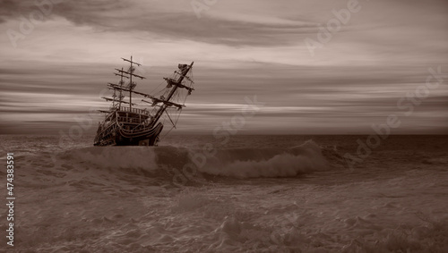 Old Sailing-ship in storm sea, dramatic sunset in the background