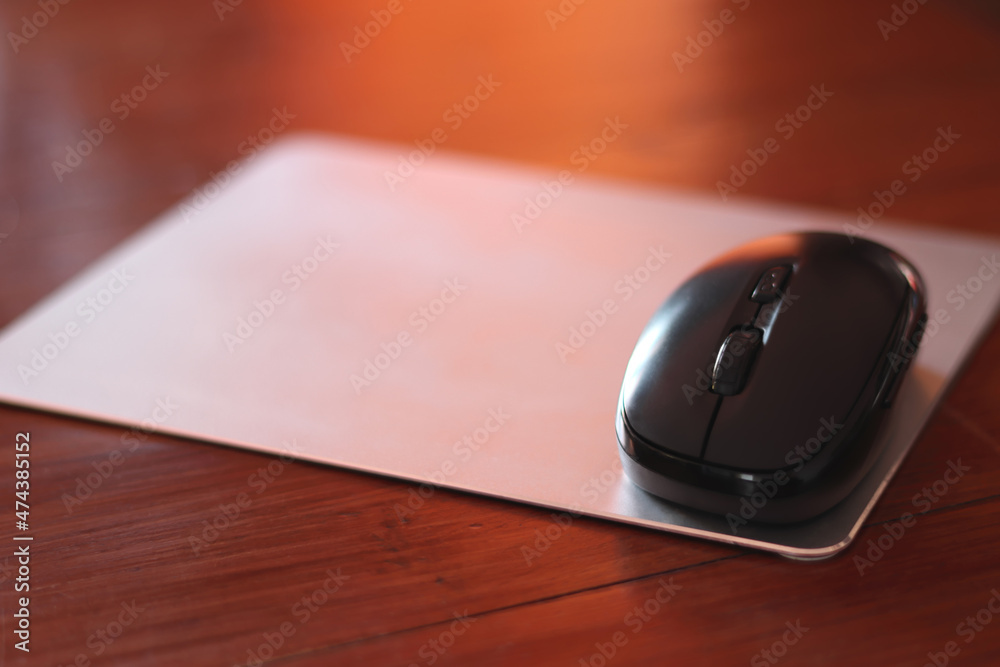 a black wireless mouse on wooden table a black wireless mouse on wooden table