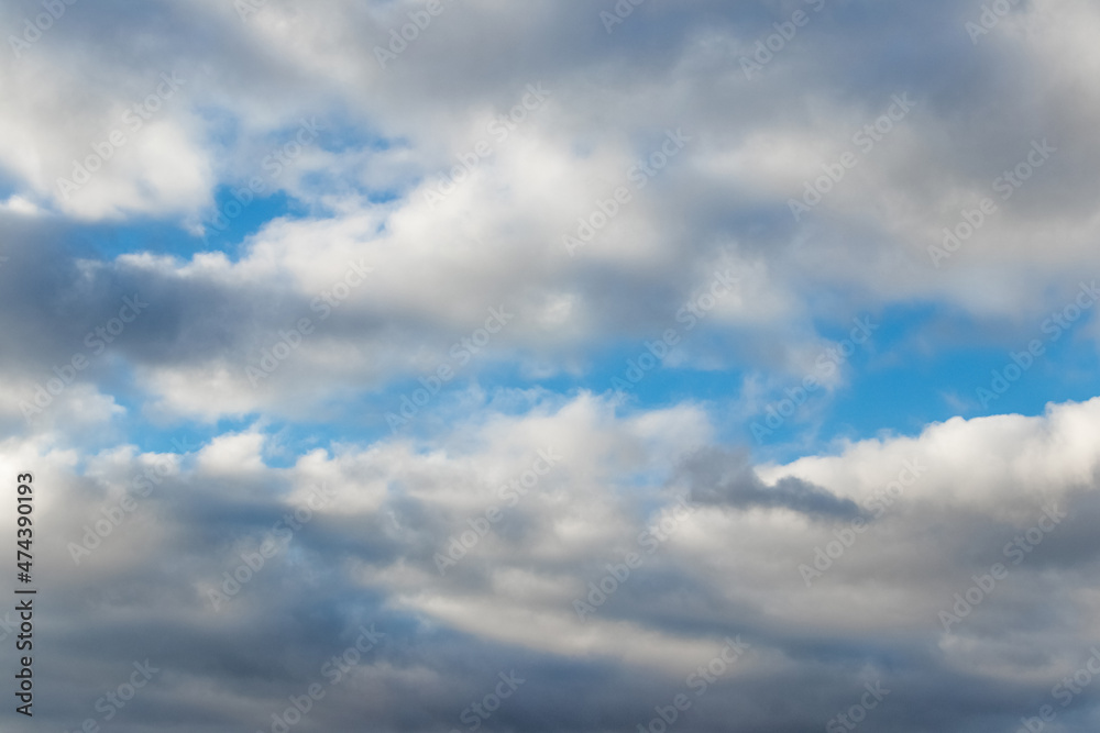 White fluffy clouds densely cover the blue sky