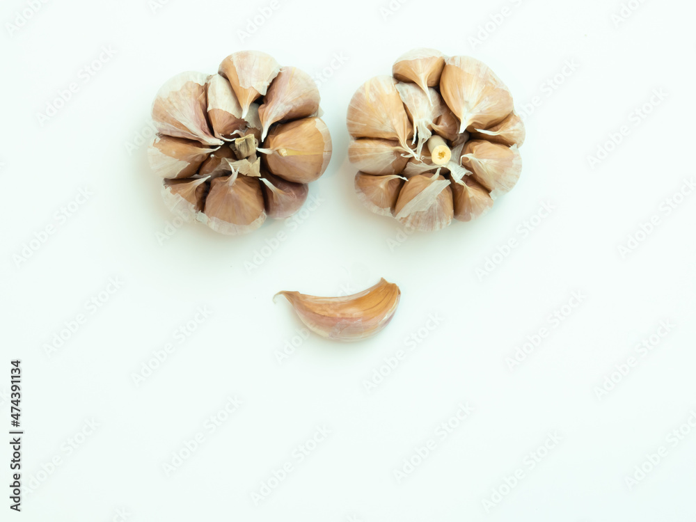 Funny Smiley Face Emoticon Made From raw garlic on white background. Peeled whole garlic in cloves on white plate and isolated on white background with negative space.. Funny Smiley Face Emoticon Made From raw garlic on white background. Peeled whole garlic in cloves on white plate and isolated on white background with negative space..