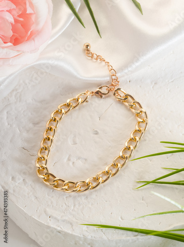 Fashion bijouterie - a large gold chain bracelet on a white stand