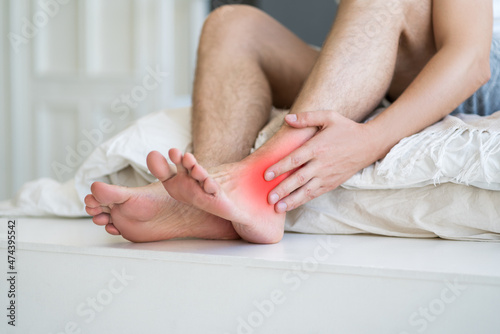 Joint inflammation, foot pain, man suffering from feet ache at home, podiatry concept photo