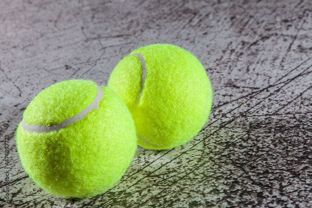 Close up of tennis balls on asphalt tennis court