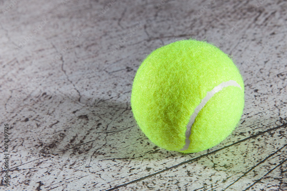 Close up of tennis ball on asphalt tennis court