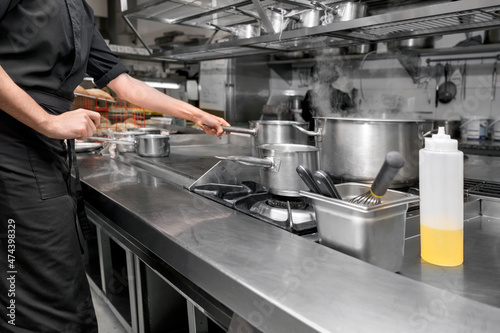 Unrecognizable Chef cooking in modern industrial kitchen. High quality photo