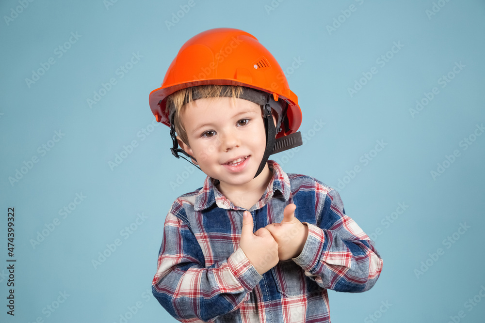 Funny boy engineer or architect in a protective orange helmet showing thumb up. Funny boy engineer or architect in a protective orange helmet showing thumb up.