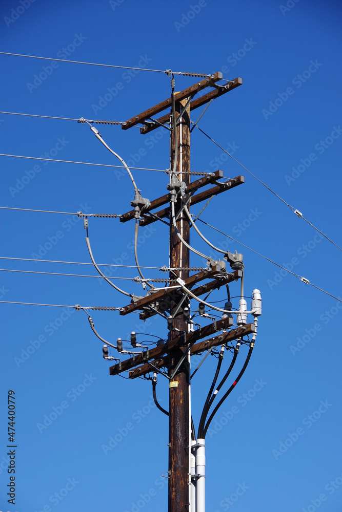 Low angle close-up view of a wooden electricity pylon for overhead power distribution Low angle close-up view of a wooden electricity pylon for overhead power distribution