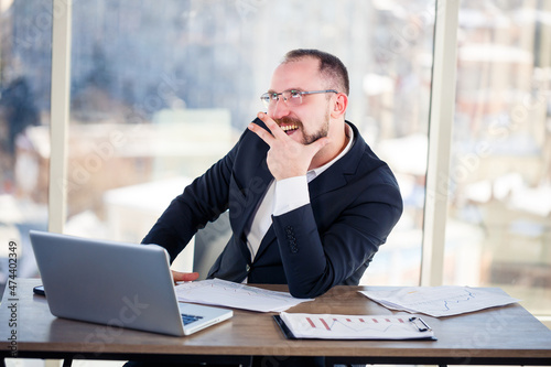 The corporate madman is sitting at the computer in the office and going crazy, the emotional portrait of the man at the table. Crazy worker at his workplace © Дмитрий Ткачук