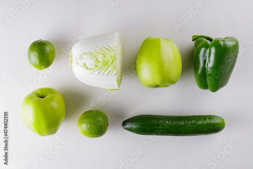 Green vegetables and fruits on white background. Healthy vegetarian food concept. Top view