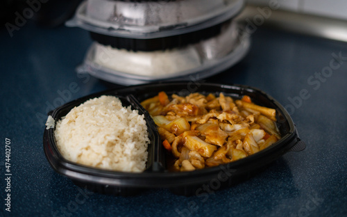 Lunch box. Food delivery ready to be taken away, all served in disposable plastic packaging, some with plastic over the top.