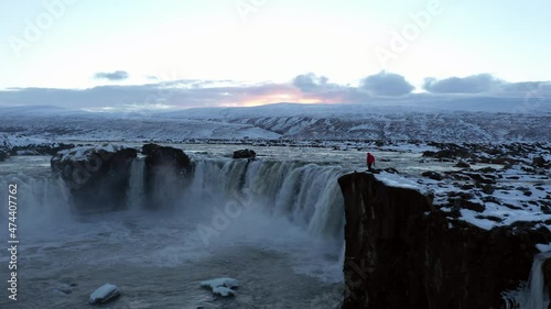 Aerial view of man walking near Godafoss waterfall, Iceland.