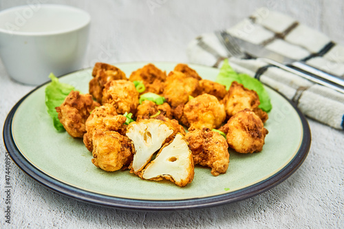 Vegan cauliflower buffalo wings on white wooden table.Tasty vegetarian food top view. crispy fried cauliflower bites